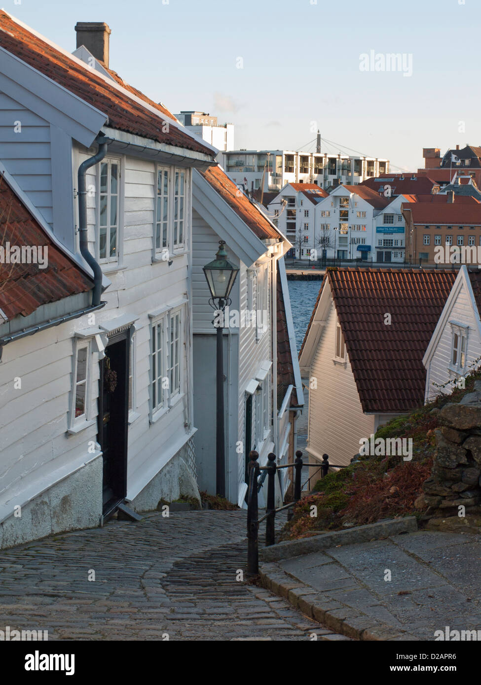 Steep cobbled street and wooden houses in Old Stavanger  Norway .Harbour can be seen below Stock Photo
