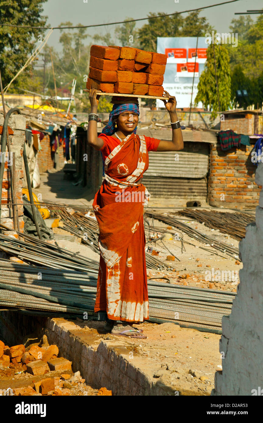 CONSTRUCTION WORKER IN INDIA CARRYING SIXTEEN BRICKS ON HER HEAD Stock Photo
