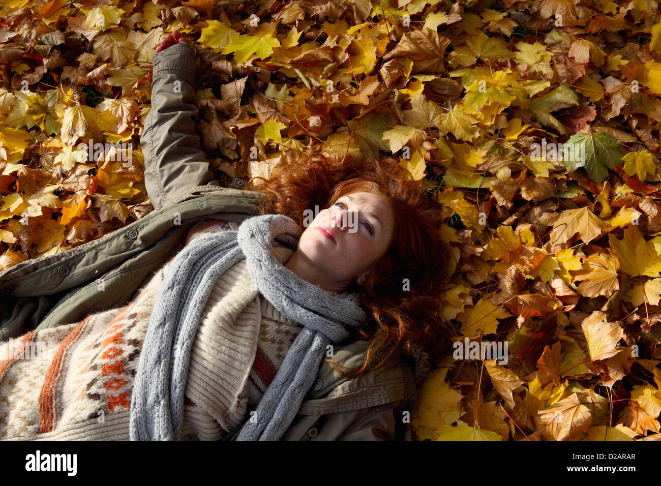 Woman laying in autumn leaves Stock Photo - Alamy