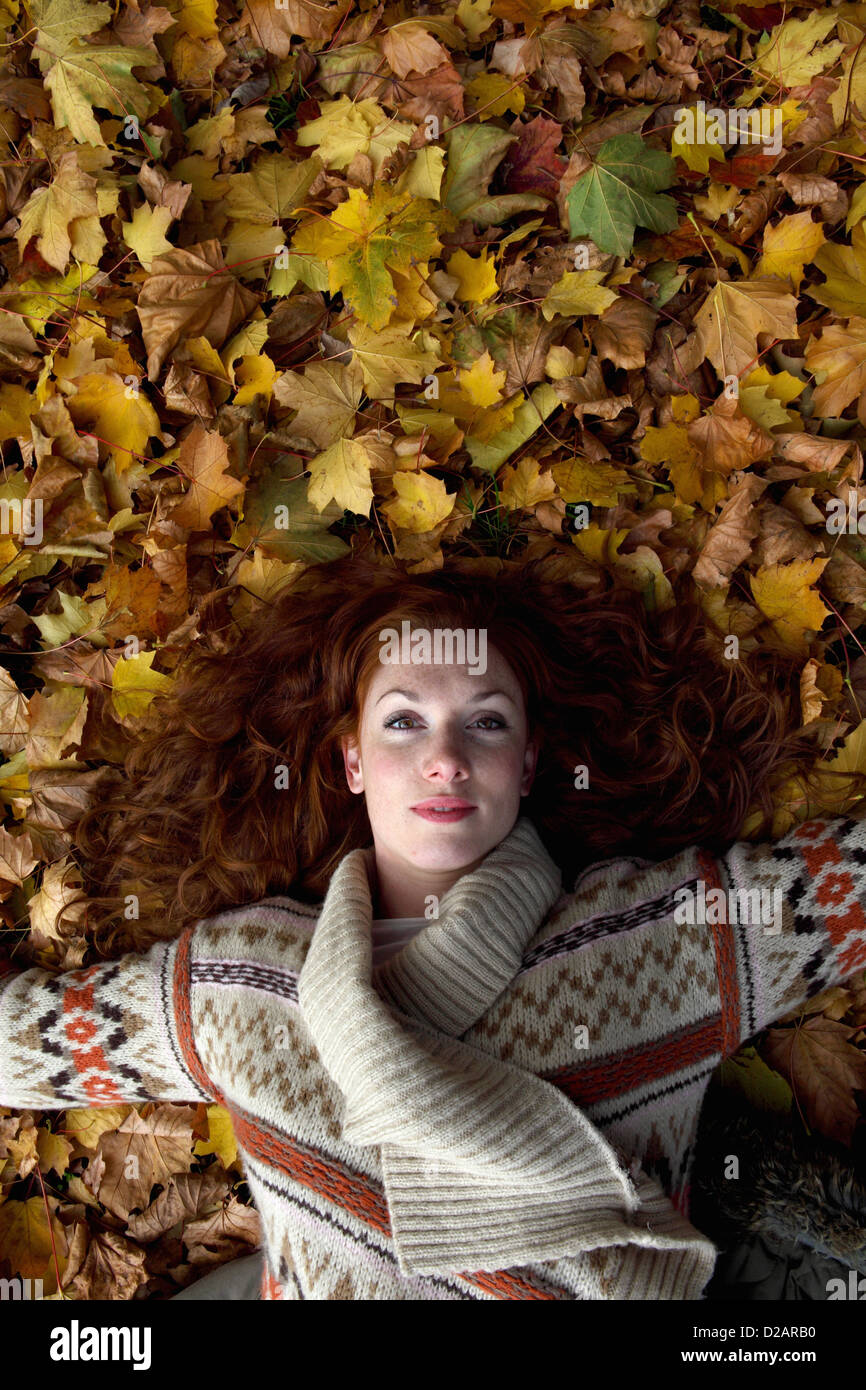 Woman laying in autumn leaves Stock Photo - Alamy