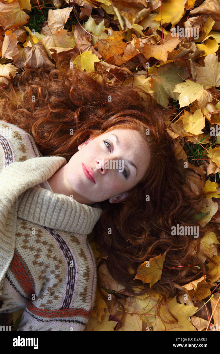 Woman laying in autumn leaves Stock Photo - Alamy