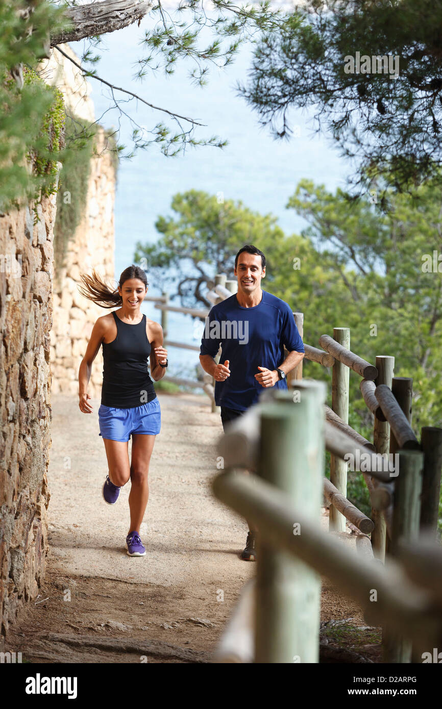 Couple running on dirt path Stock Photo