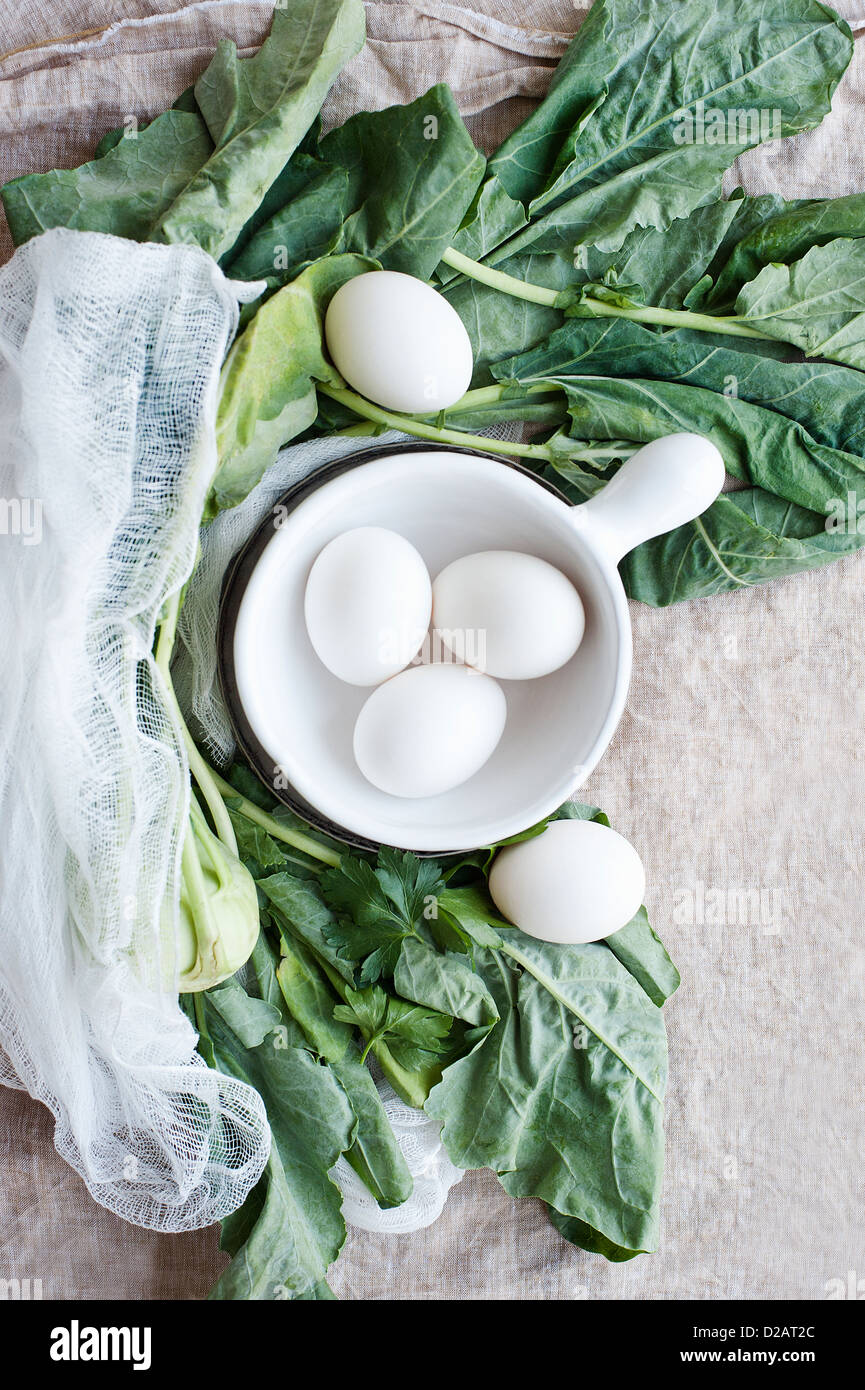 Eggs, greens and muslin cloth Stock Photo
