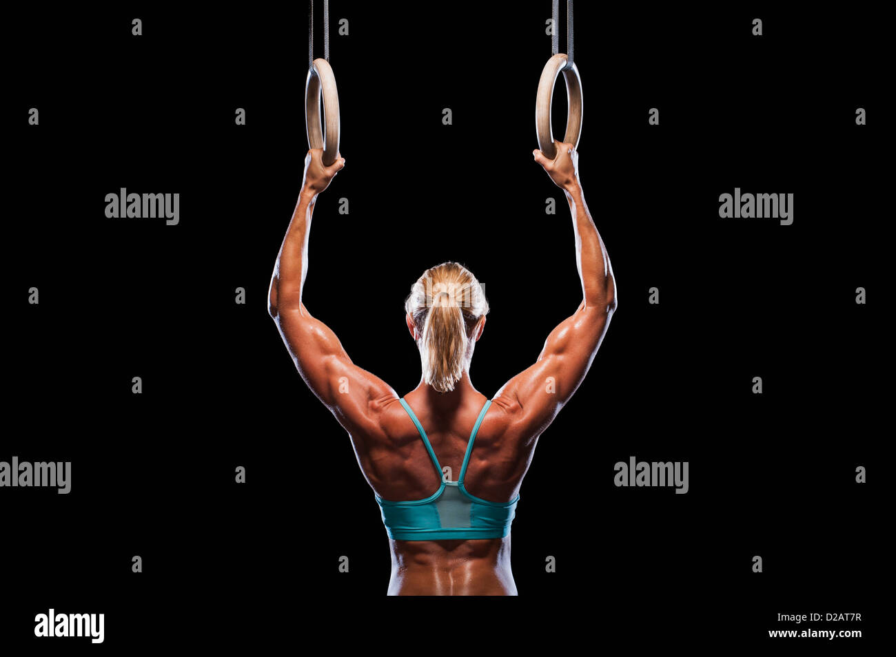 Woman using exercise rings Stock Photo