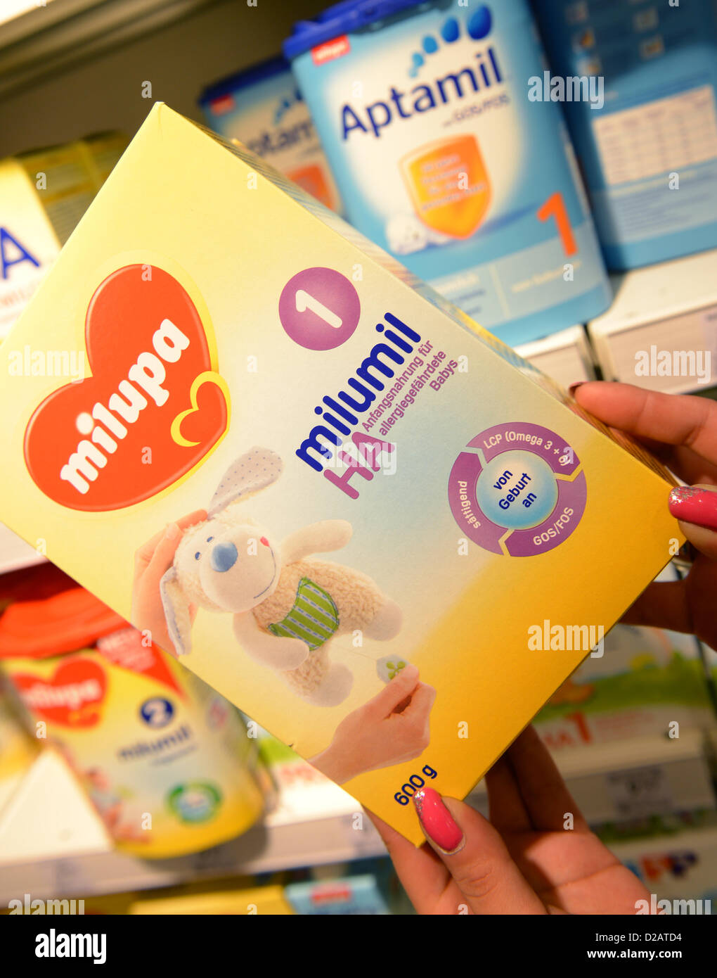 ILLUSTRATION - An illustrated picture shows a woman holding a pack of Milupa Milumil by the Danone Group in a shop in Frankfurt Main, Germany, 18 January 2013. Worries by Chinese parents for the safety of their children has caused supply bottlenecks of baby food. Demand of dried mil products Milumil and Aptamil rocketed in China in the last few months. There was a food scandal in China in 2008 beacause of milk contaminated with the industrial chemical Melamine. Photo: Arne Dedert Stock Photo