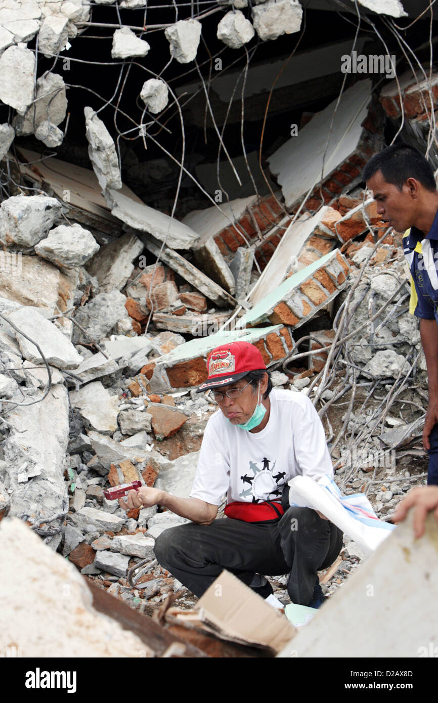 Padang, Indonesia, a desperate man sits amid the rubble of his house Stock Photo