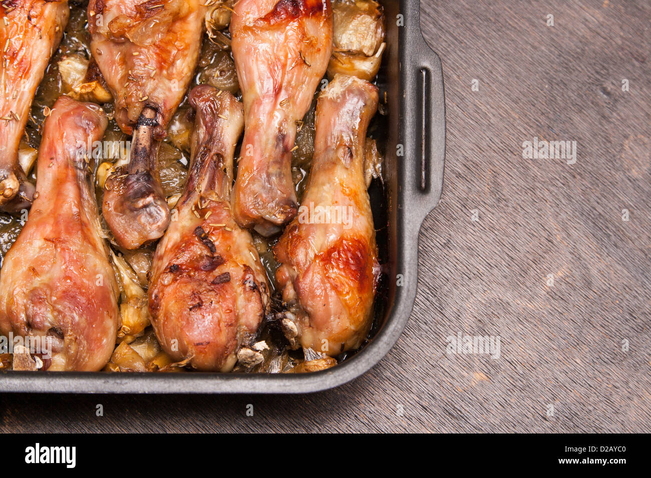 baked chicken legs in tray on black wooden background Stock Photo Alamy