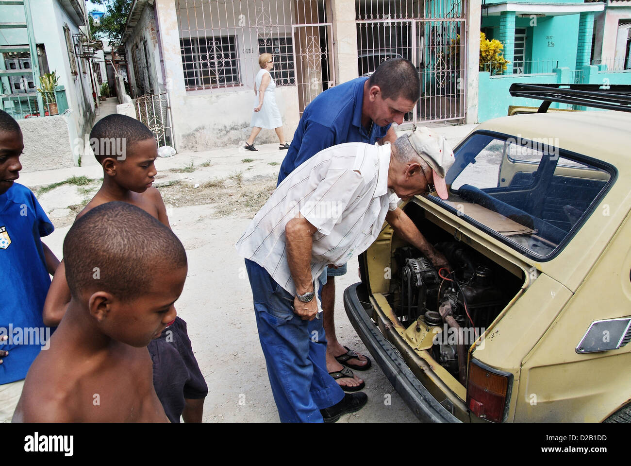 Havana, Cuba, neighbors jointly examine a car Stock Photo