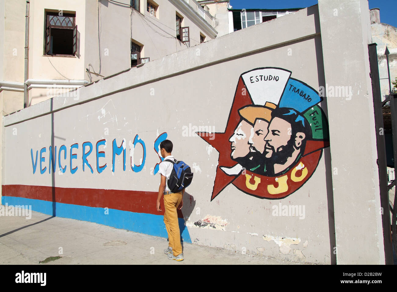 Havana, Cuba, a schoolboy walks past an advertisement of the UJC Stock Photo