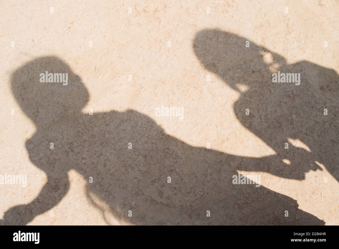 Shadow of Indian village children in a line holding hands playing games. Andhra Pradesh, India Stock Photo