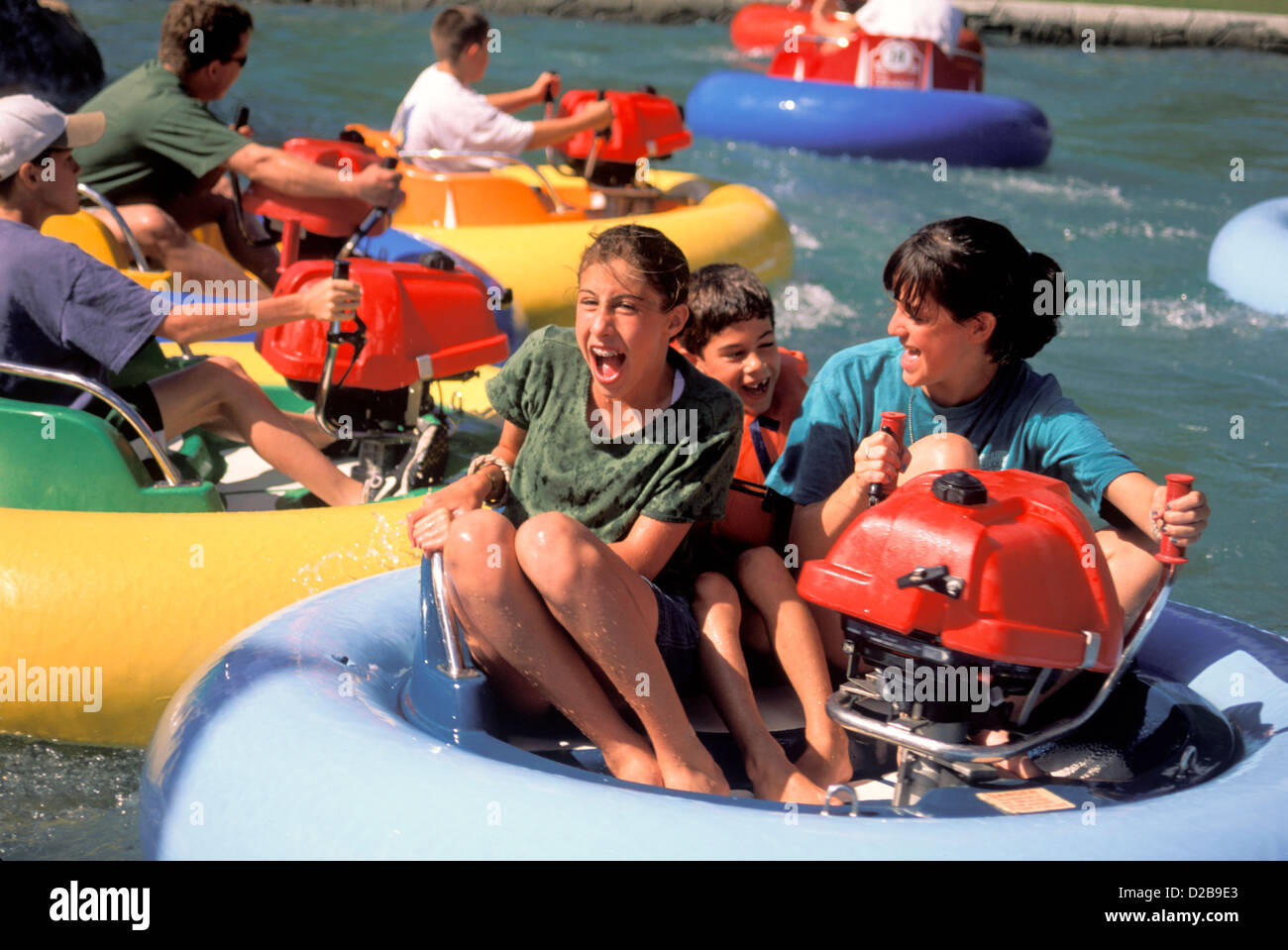 Mother And Kids Laughing While On Inner Tube Ride At Amusement Park