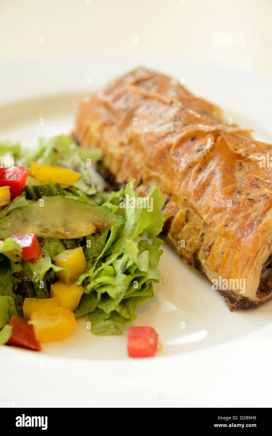 Close up shot of sausage roll on plate with white seamless background in restaurant. Stock Photo