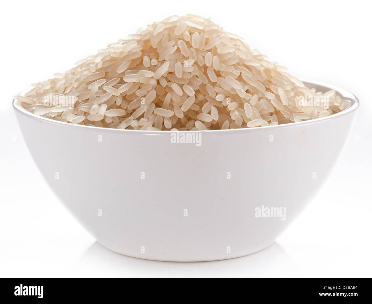 Uncooked rice in a bowl on a white background. Stock Photo