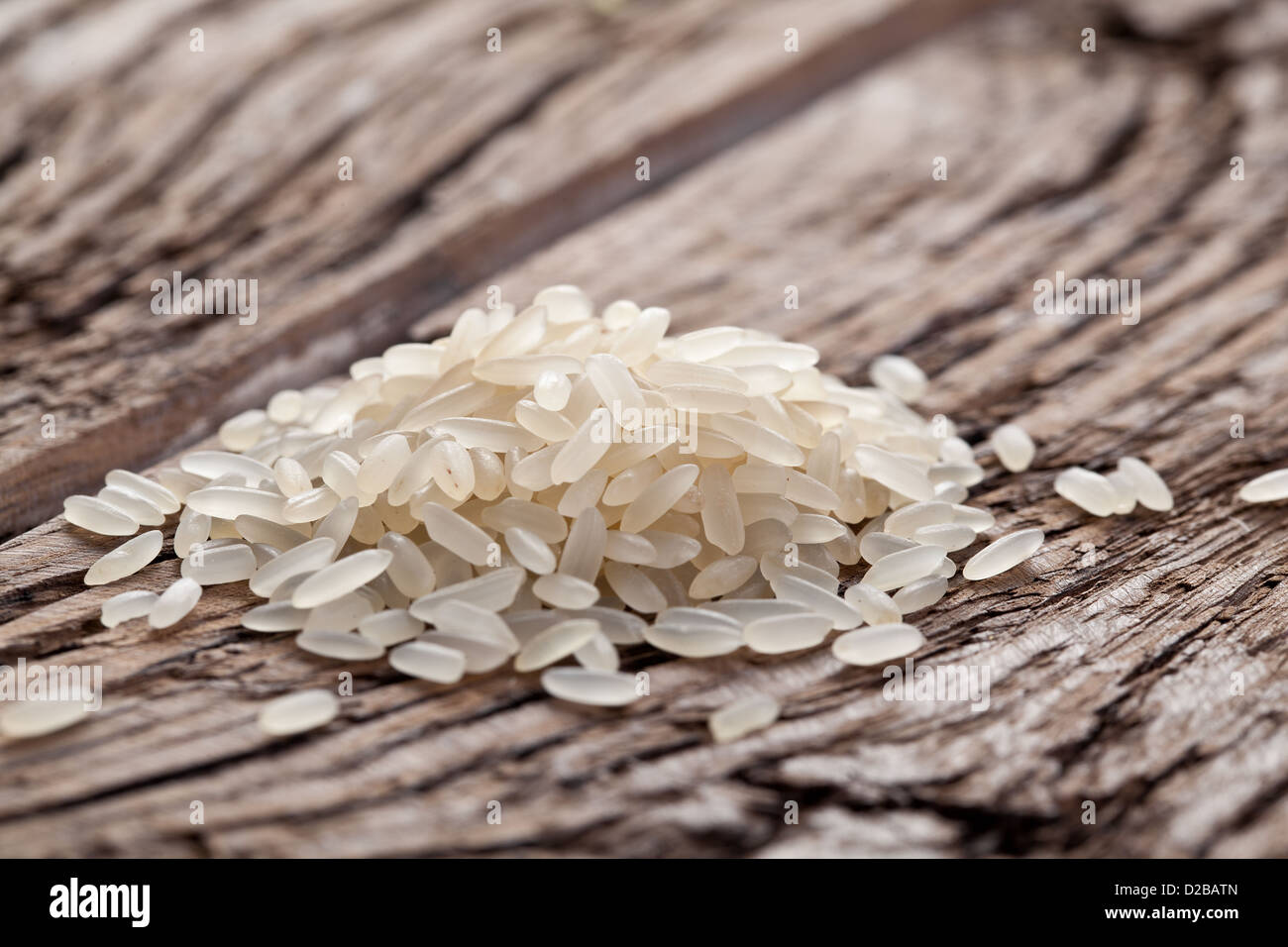 Handful of rice on a wooden table. Stock Photo