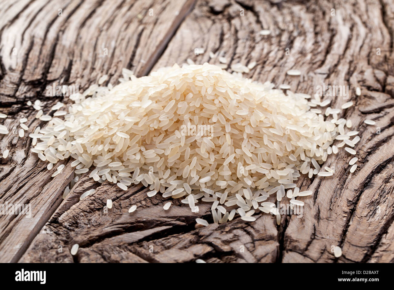 Handful of rice on a wooden table. Stock Photo