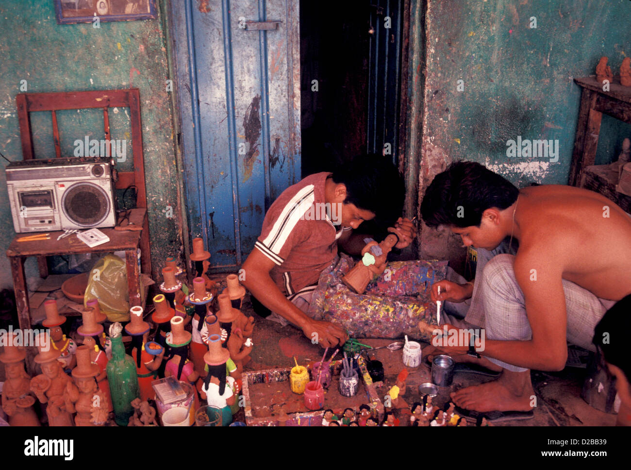 Costa Rica, 2 Men Painting Figurines Outside In Front Of Doorway Listening To Radio Stock Photo