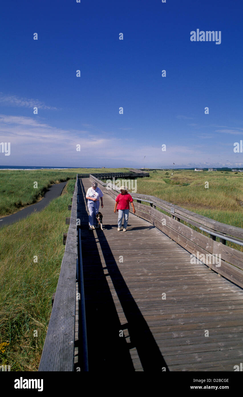 Washington, Long Beach. Two Women Walking Dog. Stock Photo