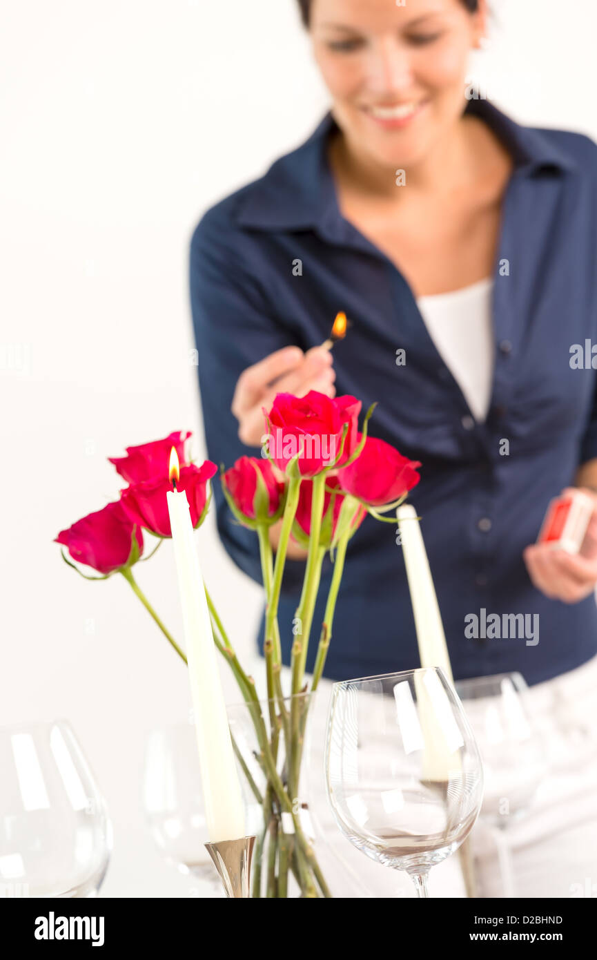 Young woman lighting candle lunch romantic love red roses Stock Photo Alamy