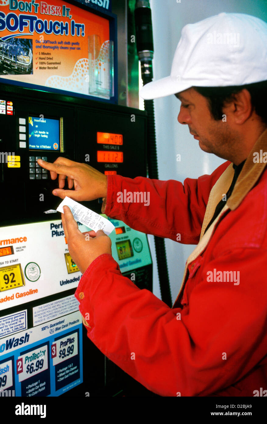 Man Using Automated Pump At Gas Station. Accepts Credit /Debit Cards