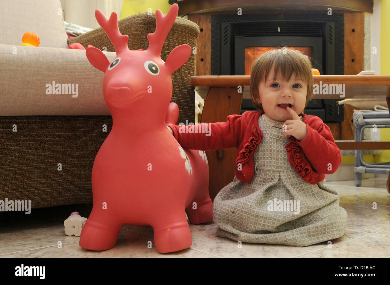 Baby girl on play-reindeer Stock Photo