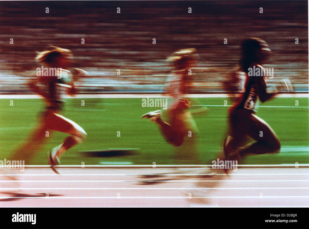 Blurred Action Shot Of Three Female Runners On Track Stock Photo