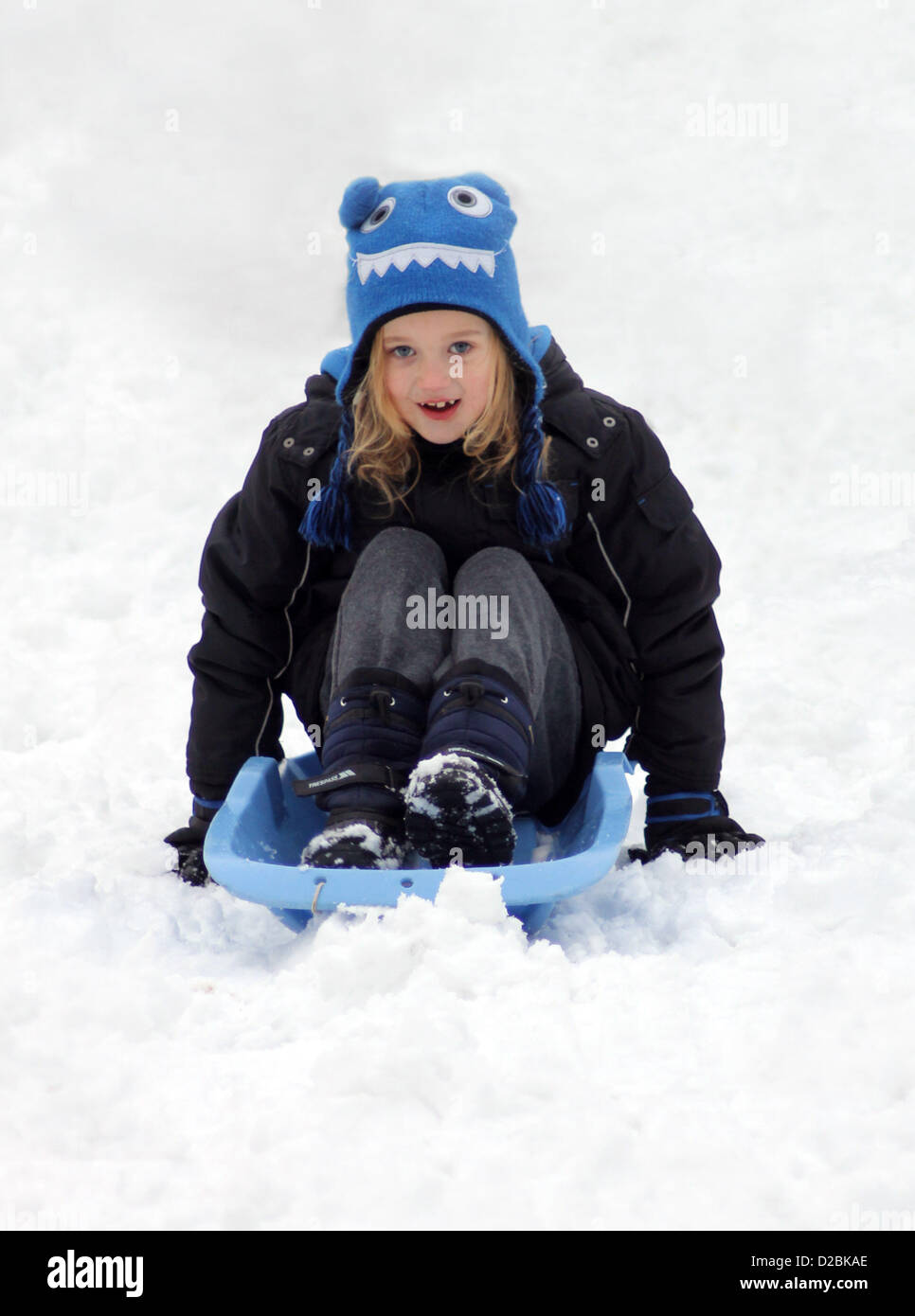 19/01/2013, Scarborough, UK. 6 year old Eve Crowdy sleges down a hill on her toboggan with a big smile. Stock Photo