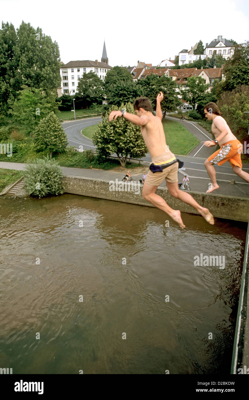 Germany, Aschaffenburg, Teens Jumping Into Rhine River Stock Photo