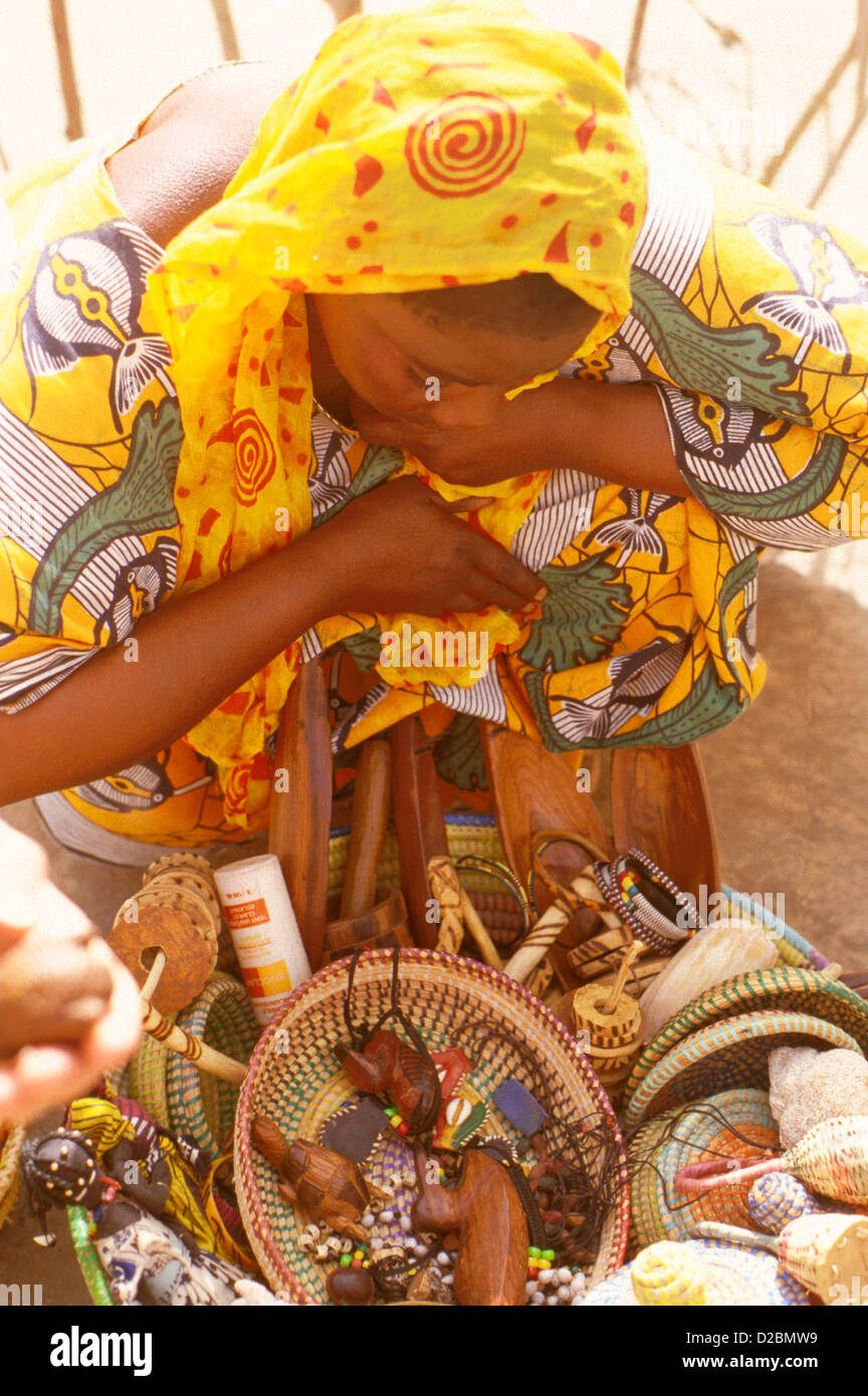 Senegal, M’Bour Region. Female Villager In Traditional Colorful Dress Selling Her Handicrafts Stock Photo