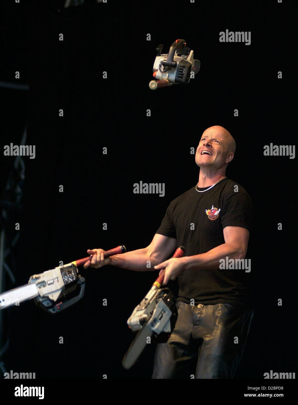 Canadian stunt preformer Tom Comet juggling 3 petrol working chain saws in a world record attempt to beat 42 throws. Stock Photo