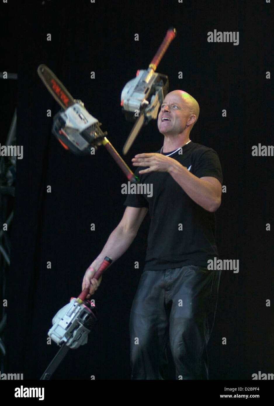 Canadian stunt preformer Tom Comet juggling 3 petrol working chain saws in a world record attempt to beat 42 throws. Stock Photo