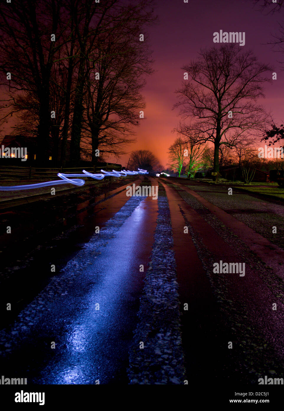 Icy street at night with red sky person walking with flash light Stock Photo