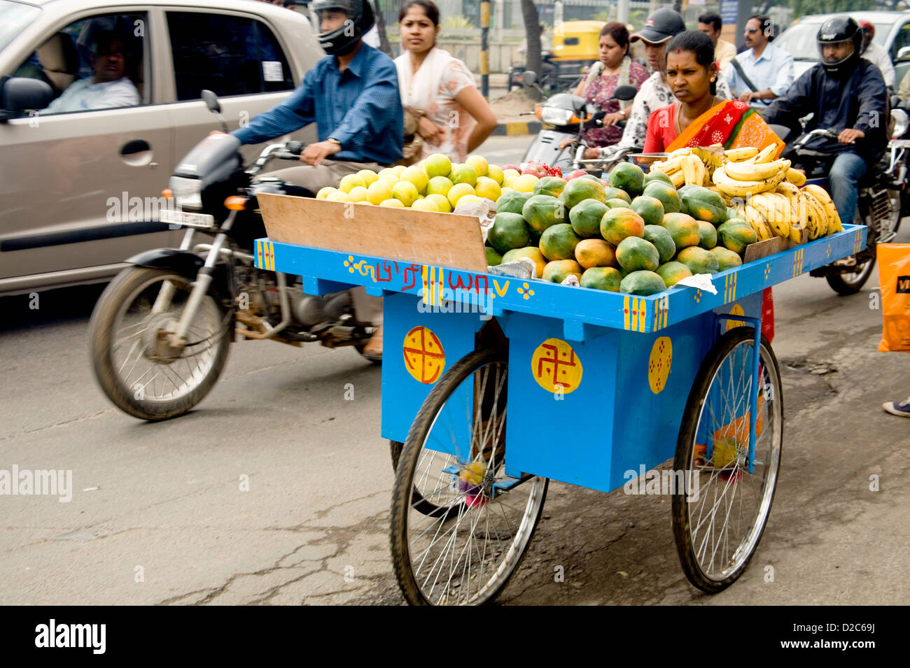 Indian Woman Selling Fruit On Blue Three Wheel Cart. Bangalore, Karnataka, India Stock Photo