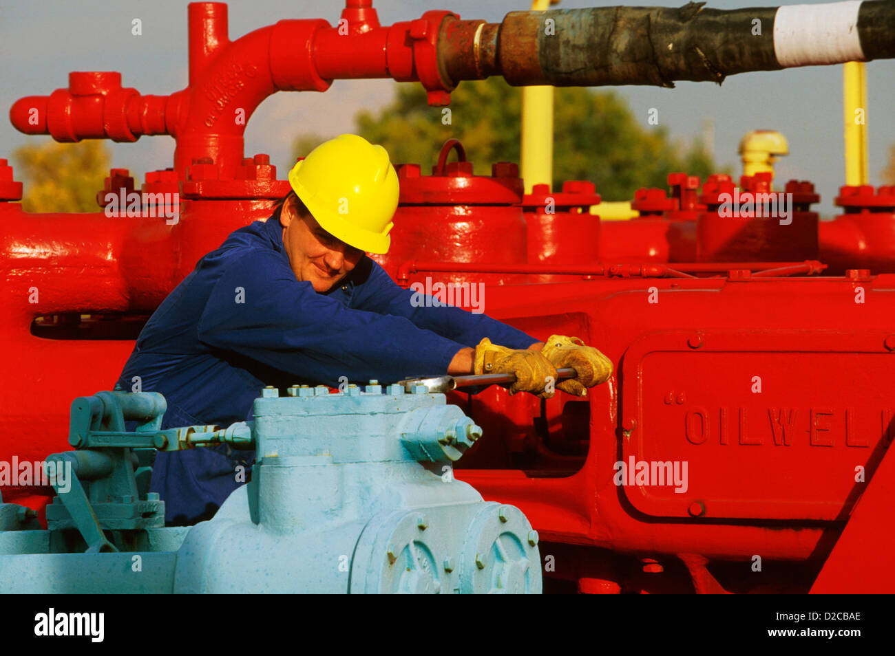 Man Making Adjustment On Drilling Rig For Oil Well Stock Photo