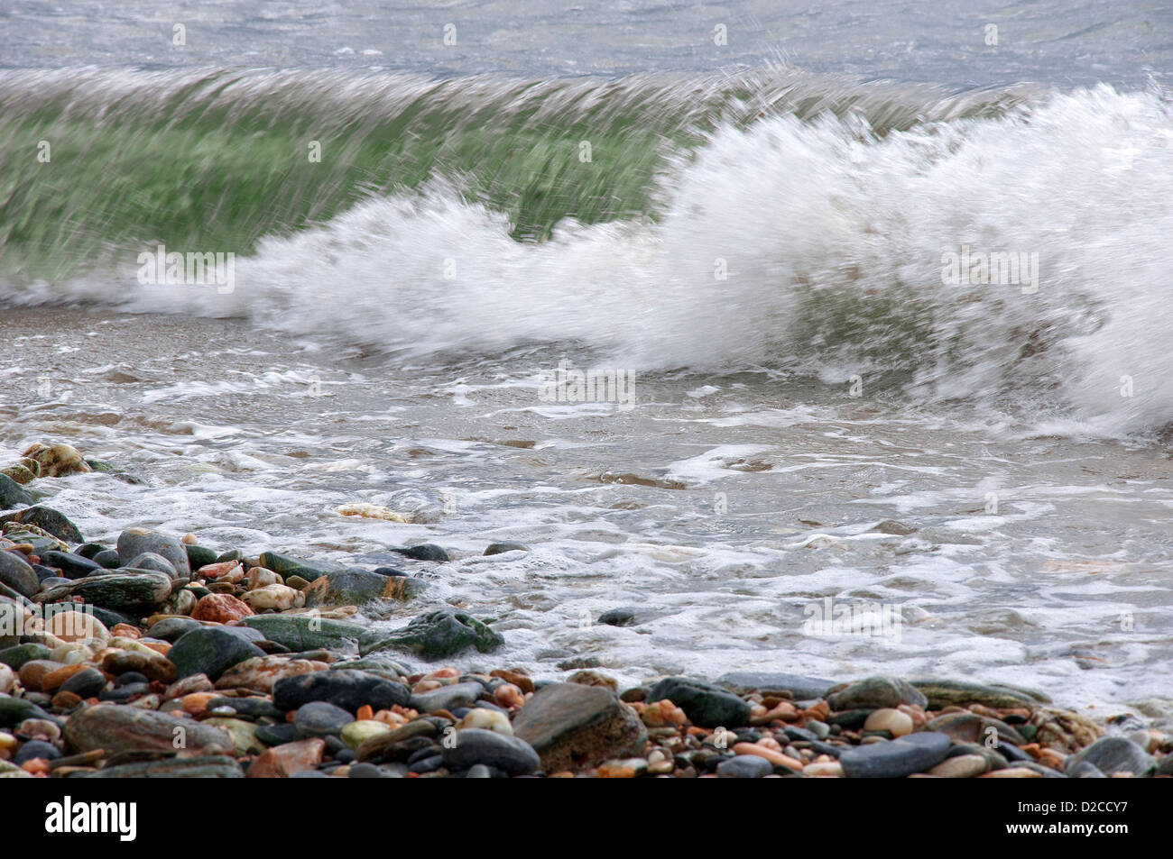 Wave breaking on pebble beach Stock Photo