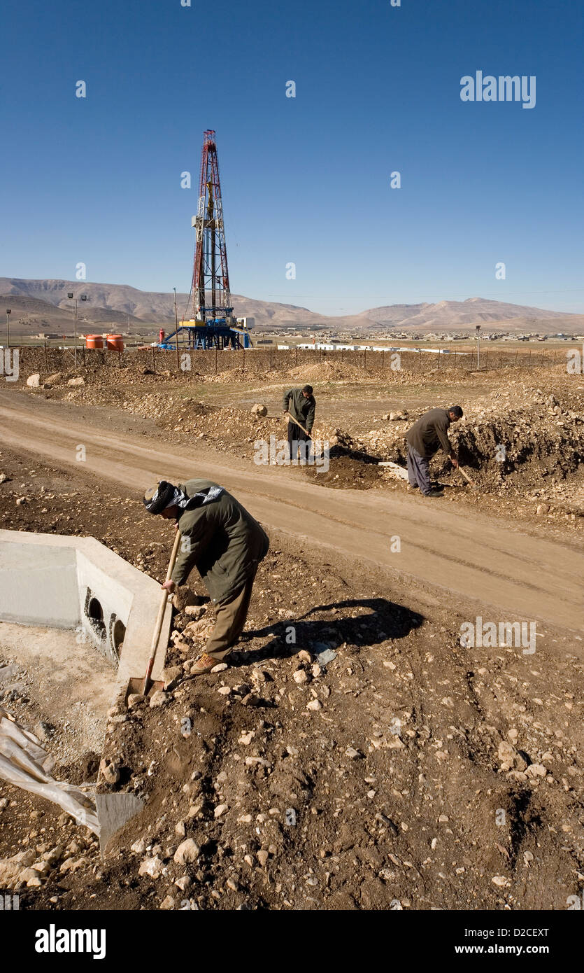 Onshore oil and gas exploration site rig platform and Iraqi Kurds from local village employed on road and culvert Kurdistan Iraq Stock Photo