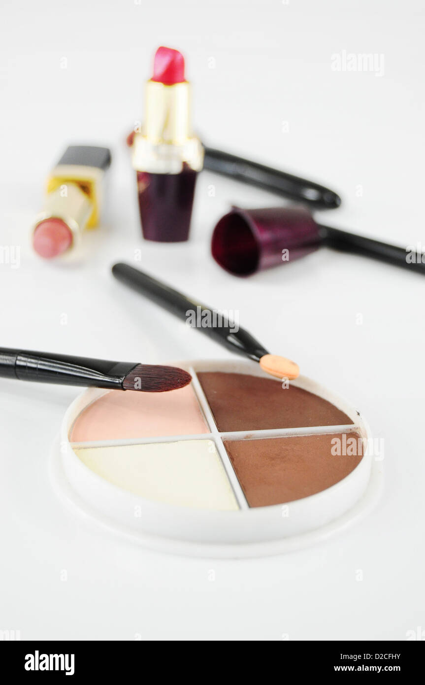 Eye-shadows and brushes, other cosmetics in the background Stock Photo