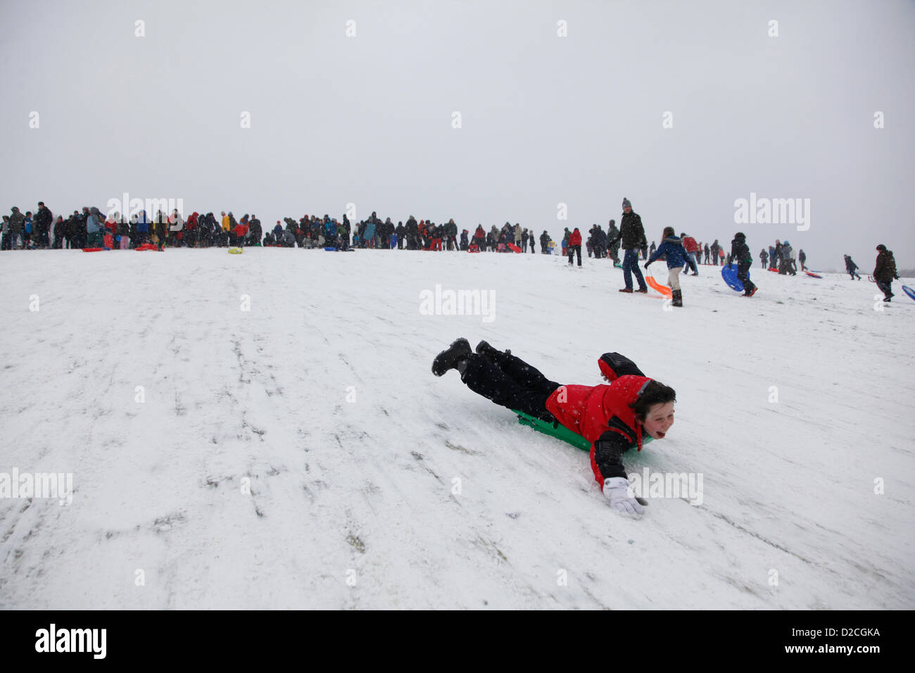 London, UK, Sunday 20th January 2013. As snow falls across the capital, Londoners spend their Sunday tobogganing down Parliament Hill on Hampstead Heath. London. Sunday 20th January 2013. Alamy Live News Stock Photo