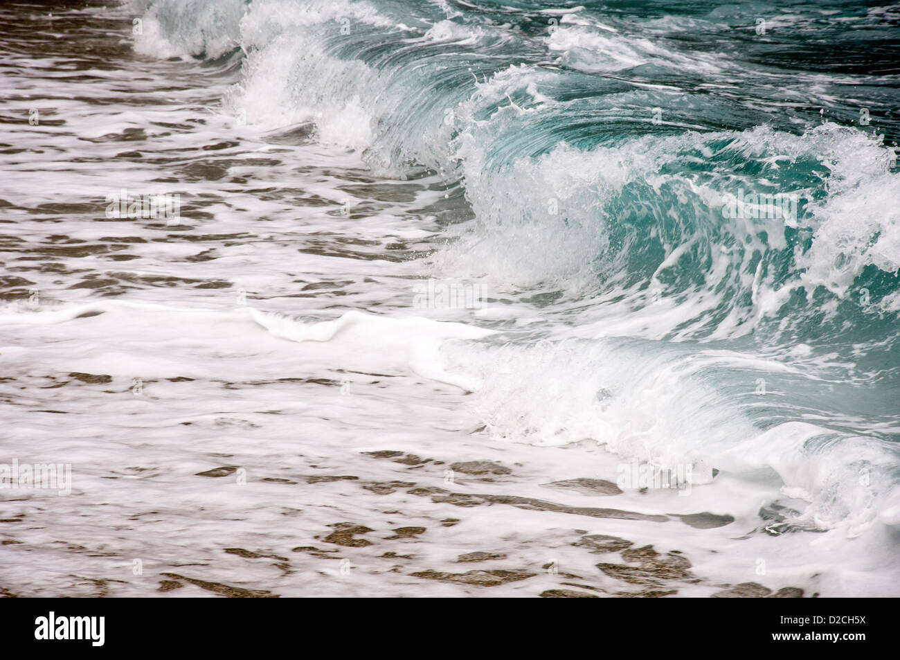 Wave on Aegean beach Stock Photo