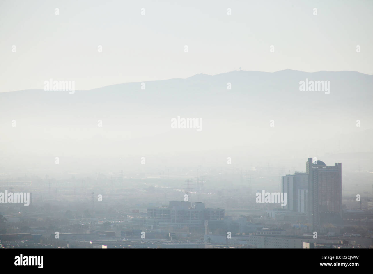 Air Pollution, Barcelona: The hot climate and surrounding mountains cause smog from industry  and cars to hang over the city. Stock Photo