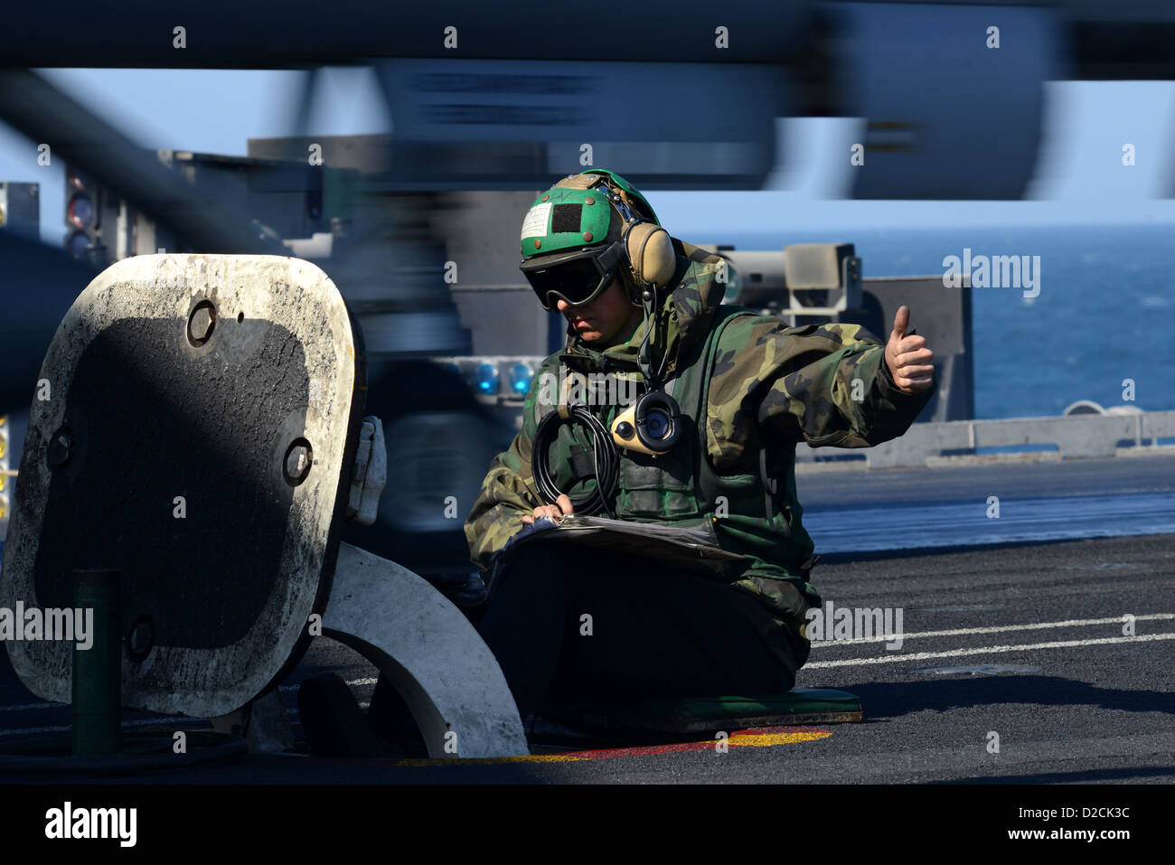  Aviation Boatswain's Mate (Equipment) Airman Kyle Cawein signals for the launch of an aircraft