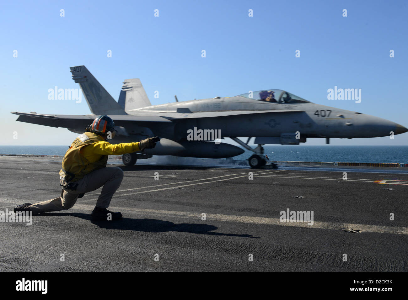 - A catapult and arresting gear officer signals for the launch of an F/A-18C Hornet from the Golden Dragons of Strike Fighter Squadron (VFA) 192 from the flight deck of aircraft carrier USS John C. Stennis (CVN 74). John C. Stennis is deployed to the U.S. Stock Photo