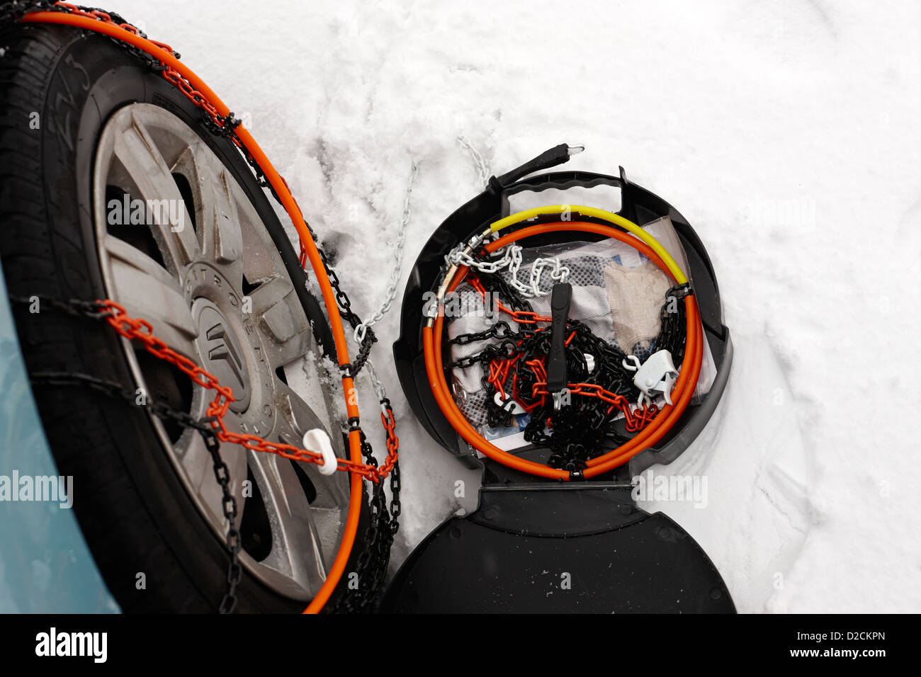 fitting snow chains to a vehicle wheel in deep snow during winter  newtownabbey uk Stock Photo - Alamy
