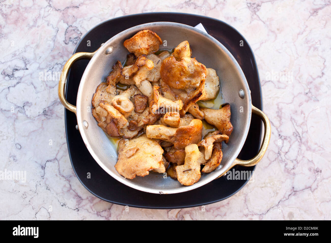 Cooked mushrooms in a copper frying pan. Stock Photo