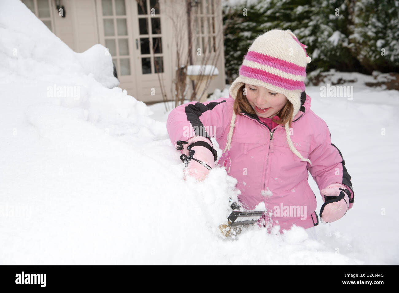 Young girl clearing snow from a car Stock Photo Alamy