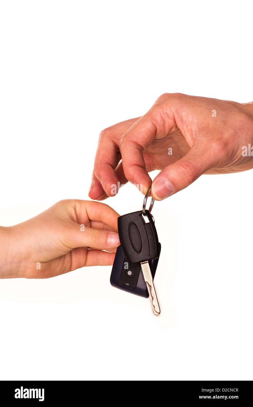 Male hand holding a car key and handing it over to another person isolated Stock Photo