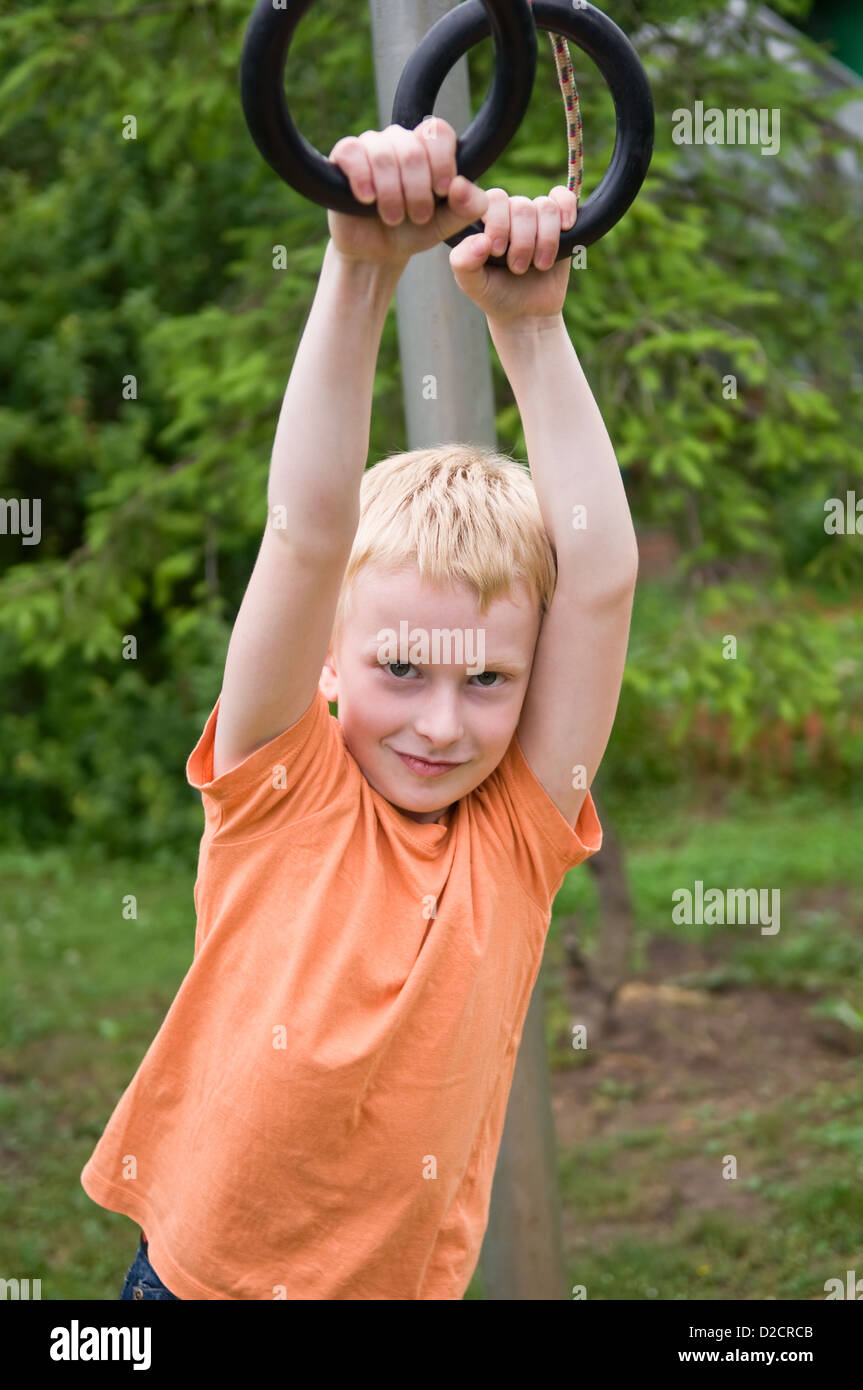 young boy exercising on gym rings outdoors Stock Photo Alamy