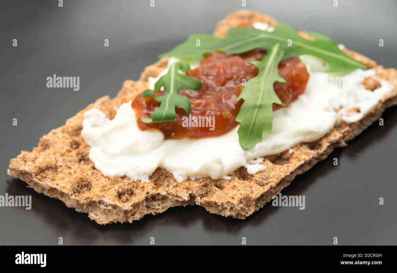 A crispbread with creamed cheese and tomato chutney - studio shot with a shallow depth of field Stock Photo