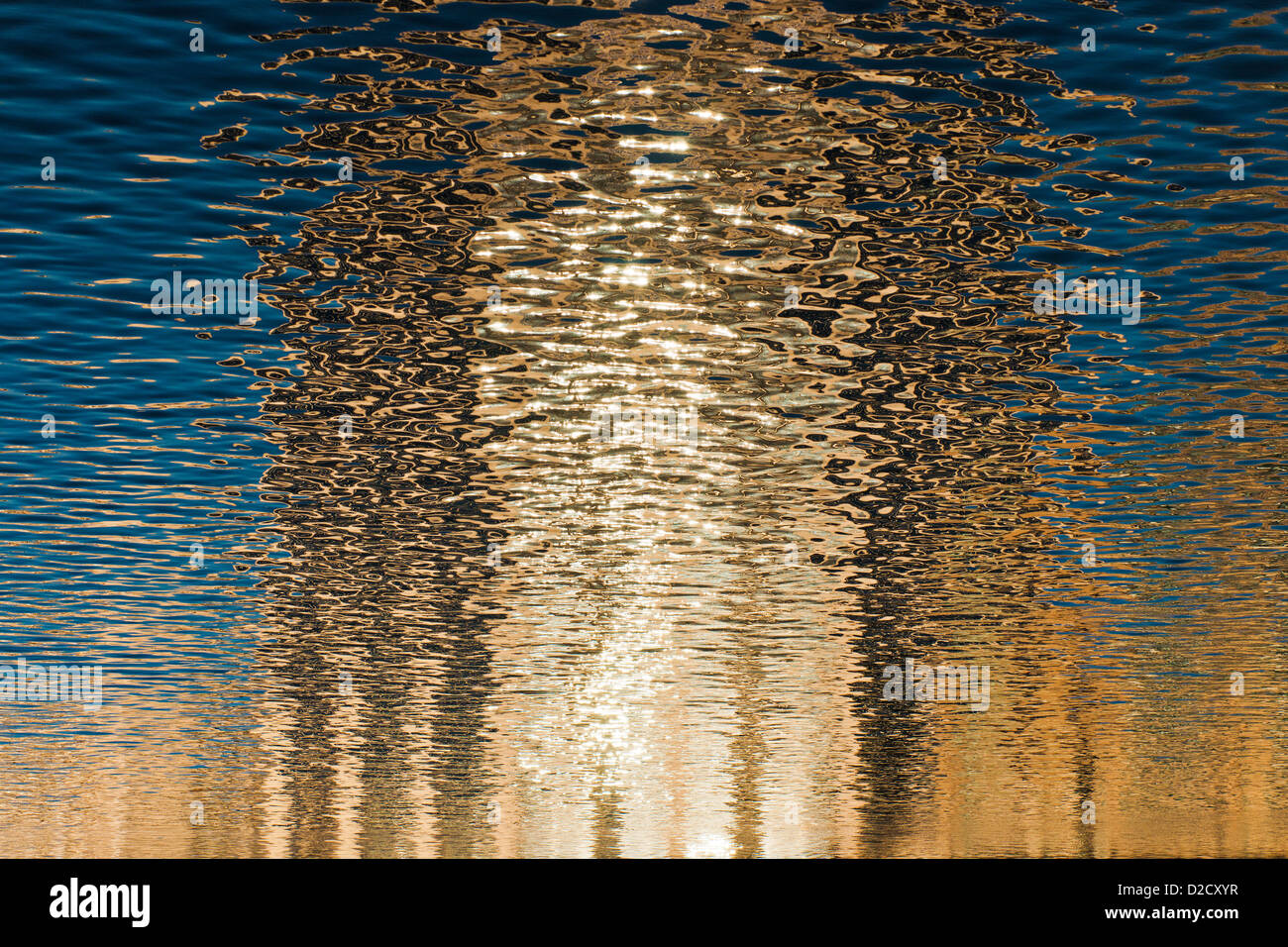 A highrise building reflects patterns onto smooth water. Stock Photo