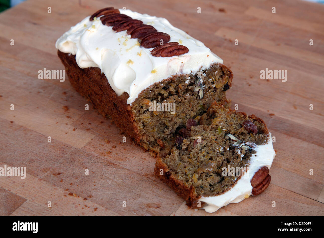 Carrot cake with cream cheese topping and decorated with pecan nuts Stock Photo