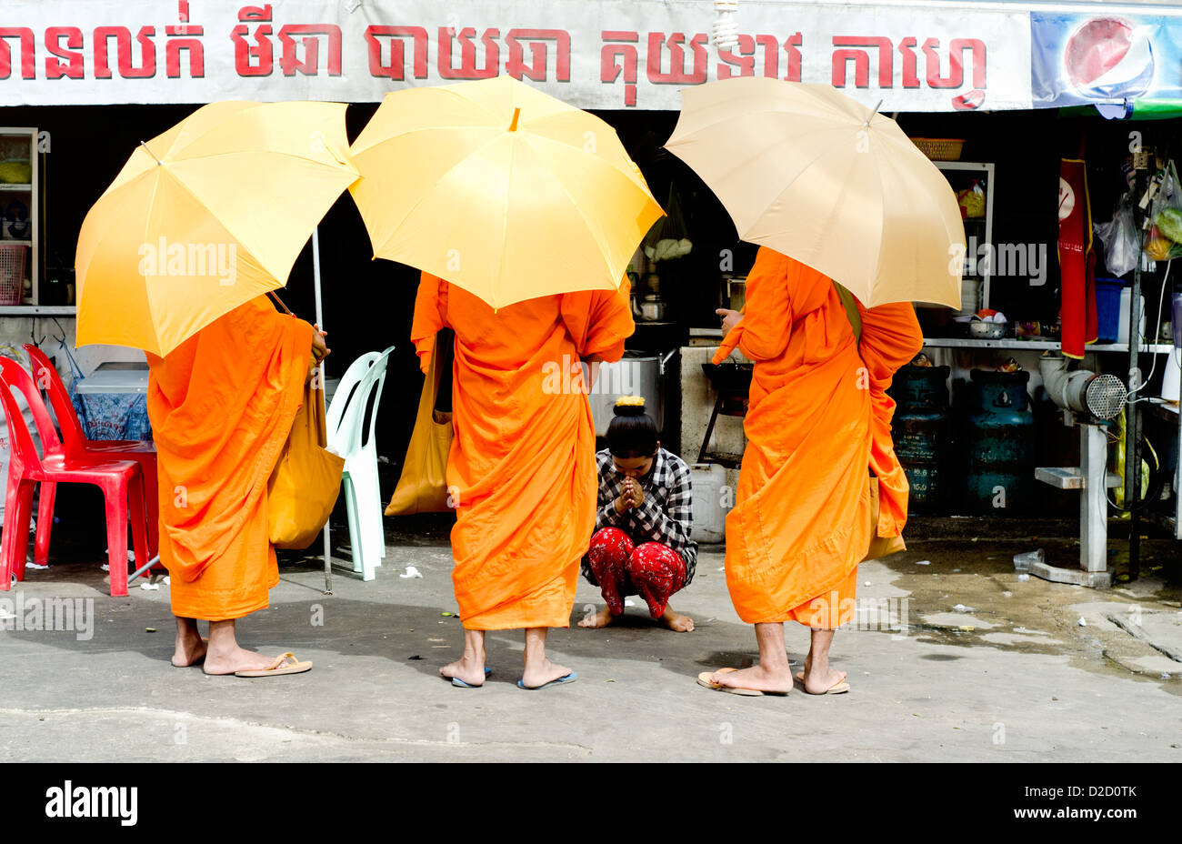 Buddhist monks begging in the front of Phnom Penh restaurant Stock Photo